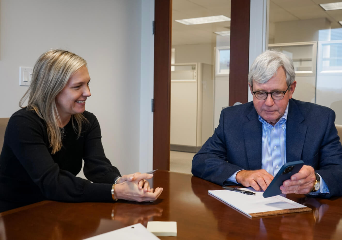 Male and female Yates employees talking at a conference table.