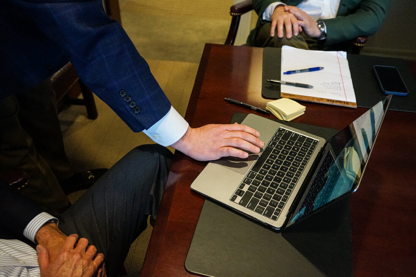 Man's hand scrolling on a laptop mouse pad.