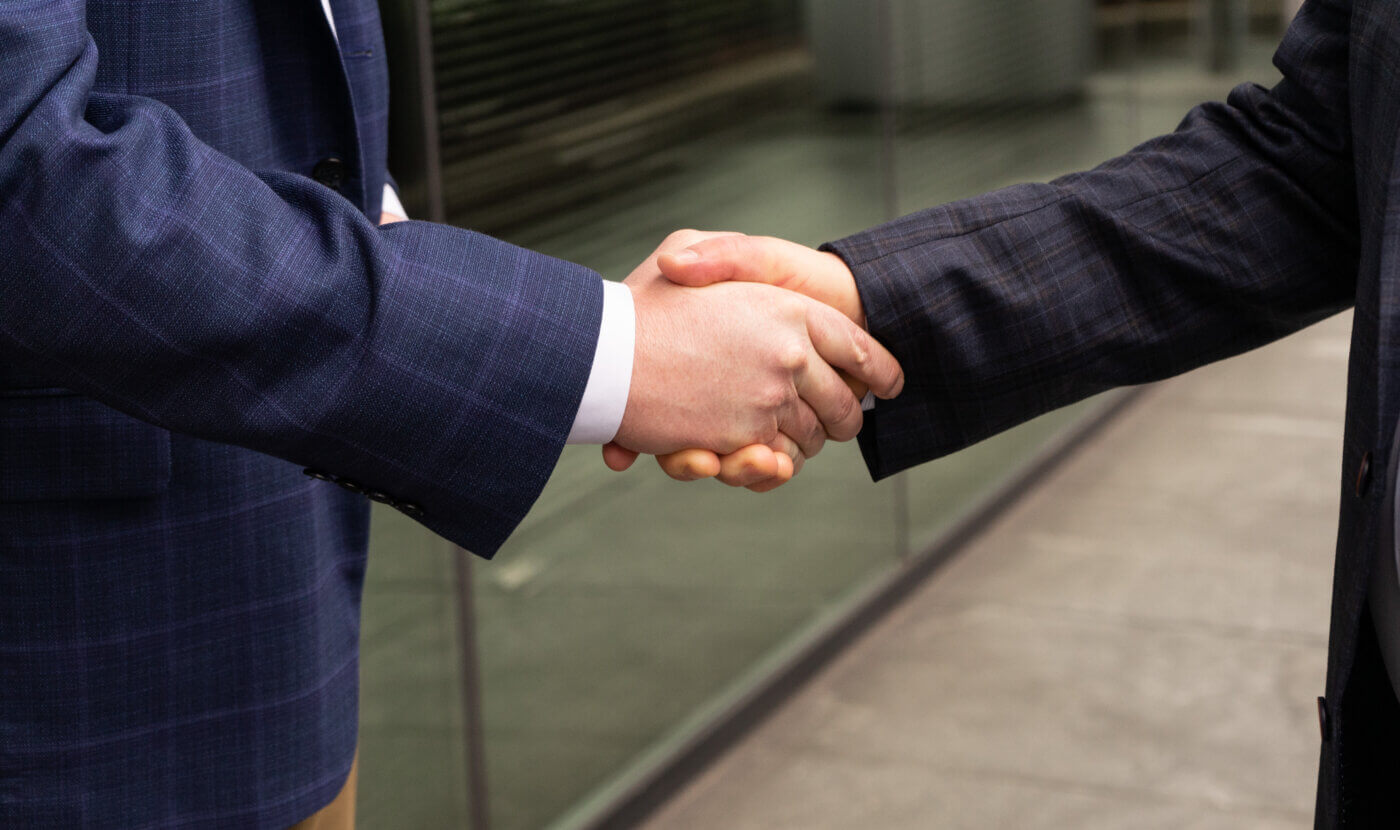 Handshake between two male Yates employees.