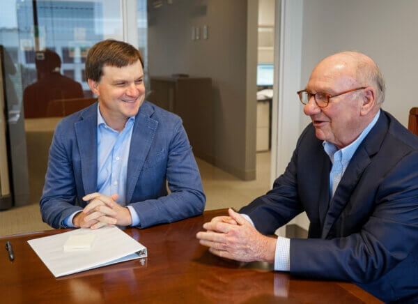 Two men at Yates sitting at conference table smiling and talking about business insurance